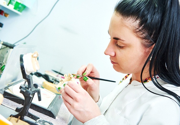 A lab technician making a custom restoration