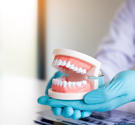 dentist working on artificial teeth 