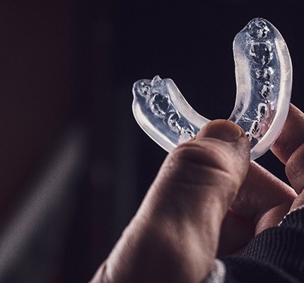An up-close view of a person holding a customized mouthguard