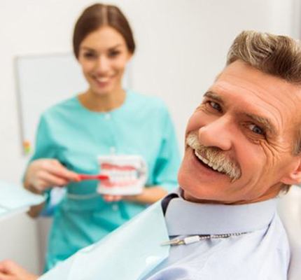 A patient and dentist smiling in a dental office