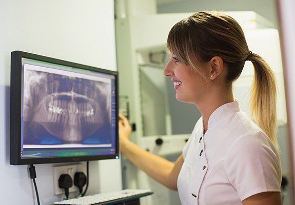 Team member looking at digital dental x-rays